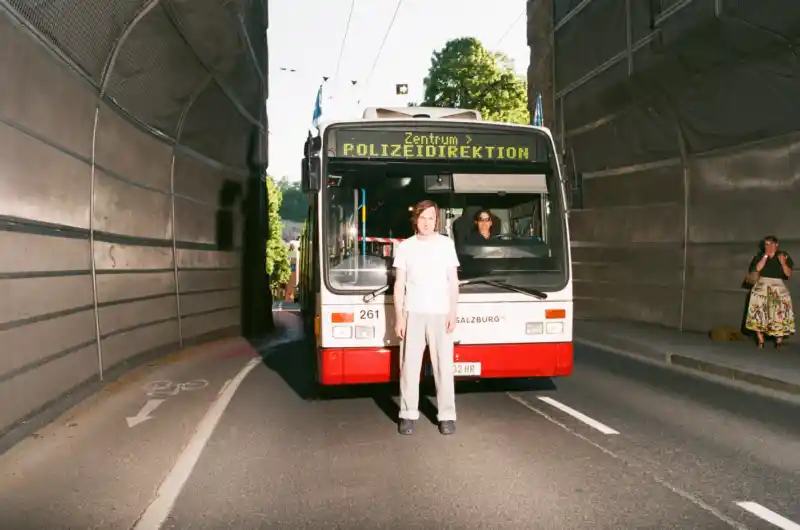 Lars Eidinger steht vor einem Bus. Maša Stanić fotografiert ihn.