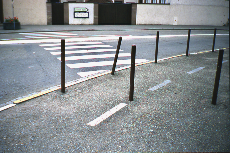 Eine Reihe schräger Metallpoller an einem Fußgängerüberweg – Pollerforschung und urbane Verkehrsregulierung im Fokus.